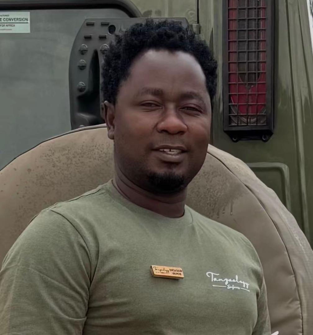 Dickson Ketto, Director of Tanzaology Tours & Safaris, beside a company safari vehicle